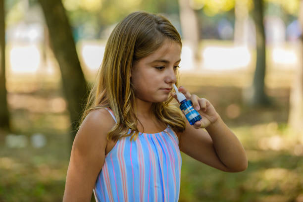 istock A Cute Girl is Having an Allergy Outside and Using Nasal Spray. 1312777769