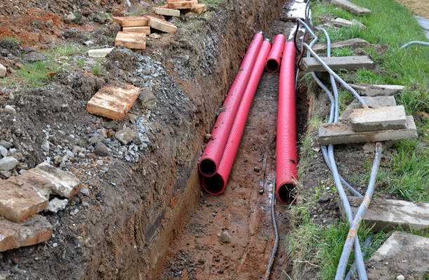 istock laying high voltage cables to the ground. the environment does not damage electric poles. Excavation meter deep in the ground black plastic coated strong cable wires. risk of electric shock in case 1312779714