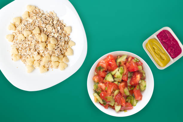 istock Healthy breakfast on a white plate on a colored background. Muesli with vegetable salad top view 1312780122