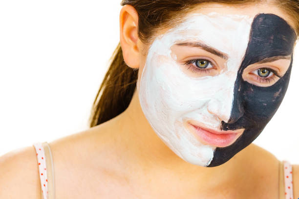 istock Girl black mask on half face apply white mud 1312780160