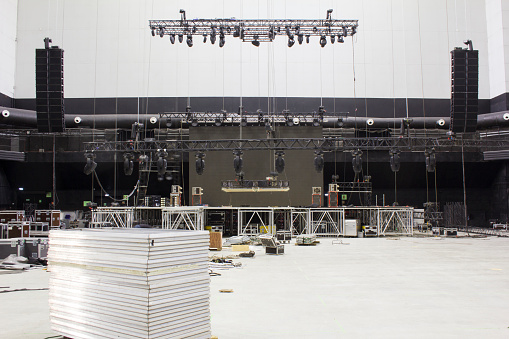 Installation of professional sound, light, video and stage equipment for a concert. Lighting devices on trusses. Line array sound speakers. Led screen.