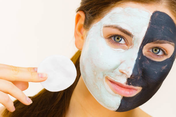 istock Girl remove black white mud mask from face 1312780939