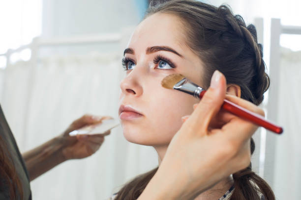 istock master does a beautiful blonde makeup in a beauty salon 1312781712