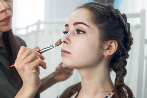 istock master does a beautiful blonde makeup in a beauty salon 1312781713
