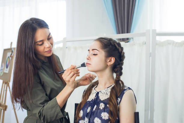 istock master does a beautiful blonde makeup in a beauty salon 1312781720
