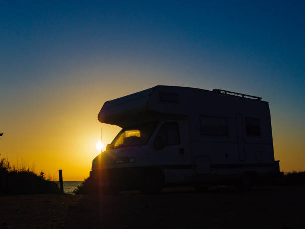 istock Camper car on beach at sunrise 1312782394