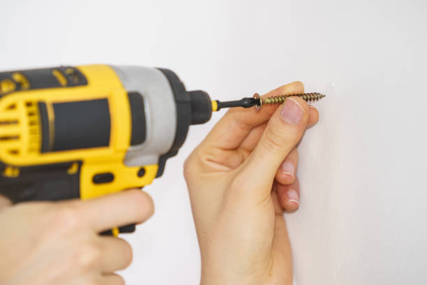 istock Person drilling in white wall 1312782776