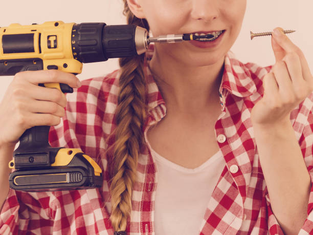 istock Woman with drill and nail screw 1312782865