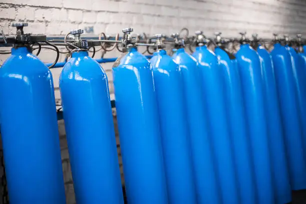 Photo of Oxygen cylinder with compressed gas. Blue Oxygen tanks for industry. Liquefied oxygen production. Factory