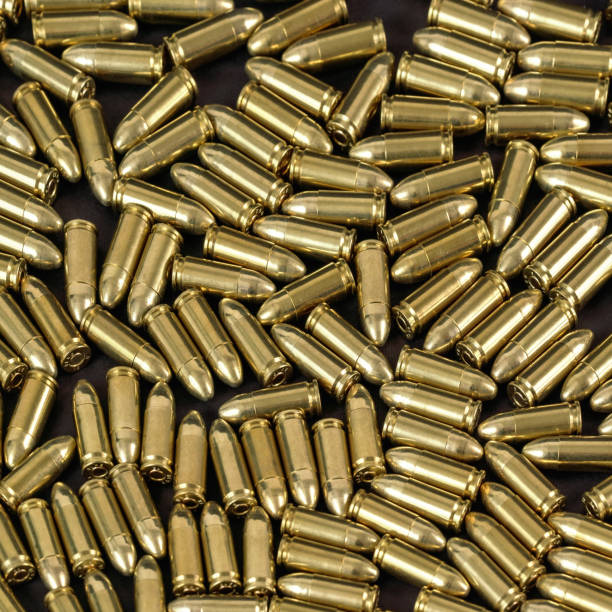 istock Many brass gun bullets on black table closeup view from above 1312784199