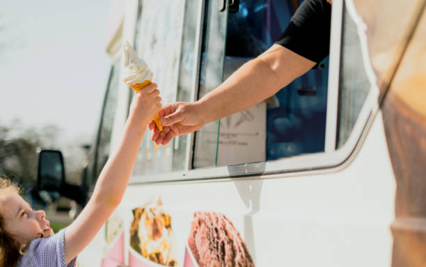 una niña feliz recibiendo helado - vendedor de helados fotografías e imágenes de stock