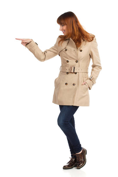 istock Young Woman In Beige Coat Is Standing, Pointing Or Pushing Something 1312785128