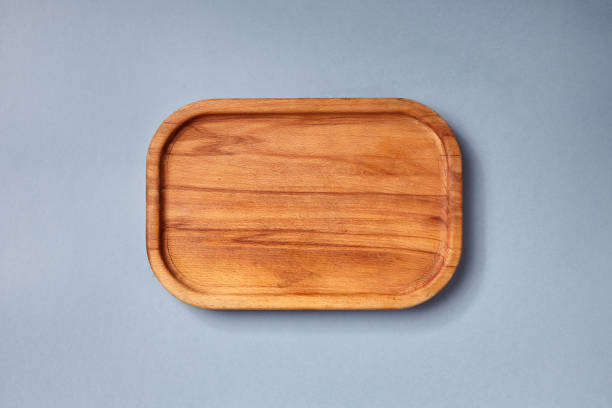 istock Empty wooden tray on textured dark blue table. Rectangular wooden dish top view. Kitchen minimal flat lay. 1312787622