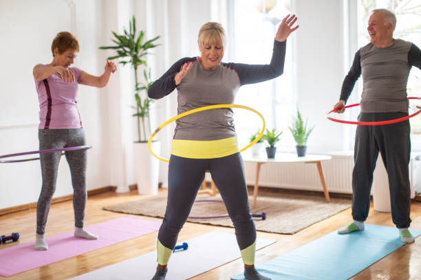 istock Senior people having fun with hula hoop during exercise class 1312788087