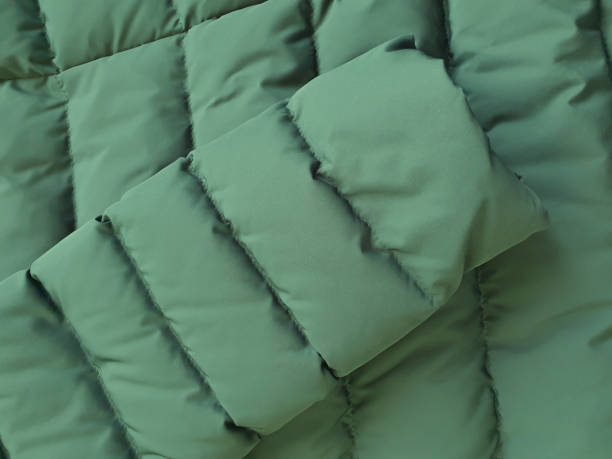istock Down jacket sleeve and fabric background, green puffer jacket texture. Top view 1312791057