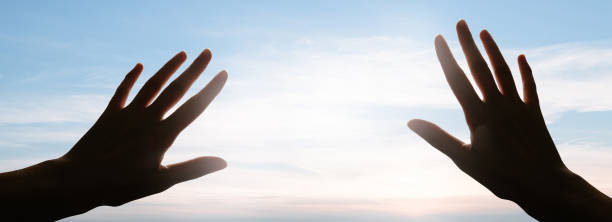 istock Hands reaching to the sky blinded by the light. Faith concept 1312801839