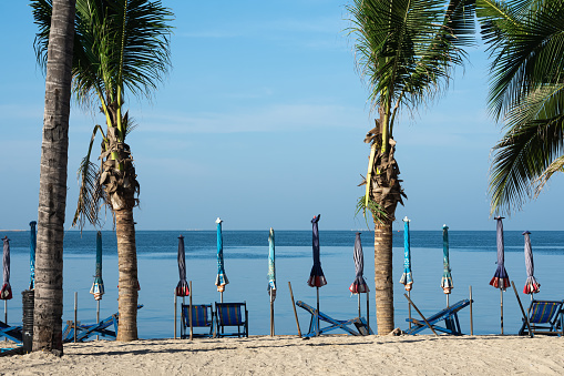 Beach chair and umbrella on the beach background.