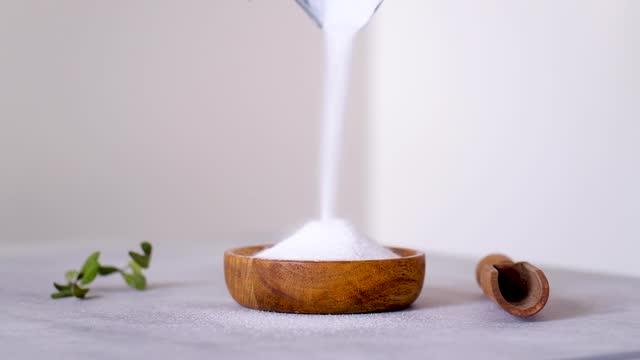 Video the natural sweetener is poured into a wooden bowl. Erythritol