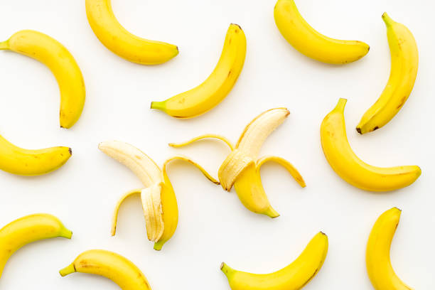 istock Whole and peeled bananas flay lay. Fruits pattern. Top view 1312803184