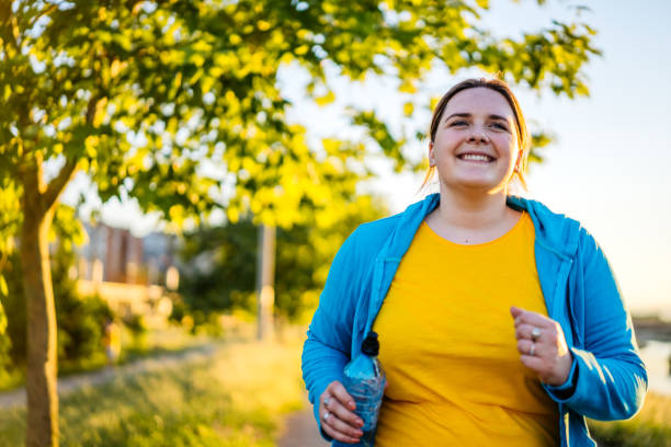 istock Young overweight woman running 1312803448