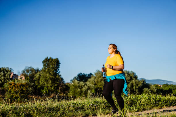 istock Young overweight woman running 1312803513