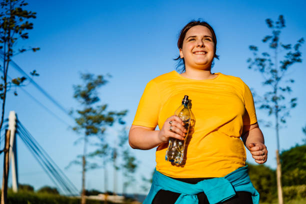 istock Young overweight woman running 1312804666