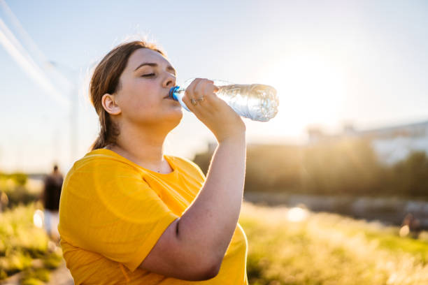 istock Oversized woman drinking water after running 1312805150