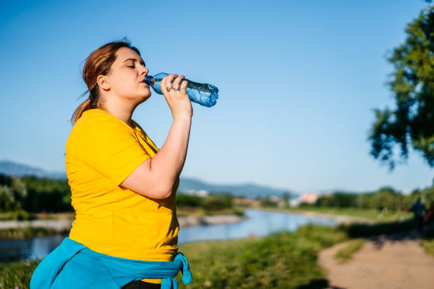 istock Oversized woman drinking water after running 1312805170