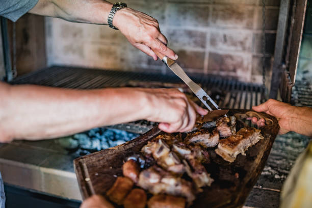 istock Two men serving meat for lunch, asado 1312805764
