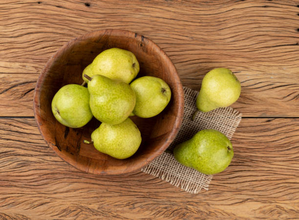 istock Green pears in a bowl over wooden table 1312805791