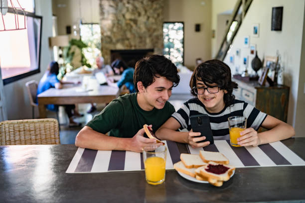 istock Teenagers having breakfast and playing on phone 1312805945