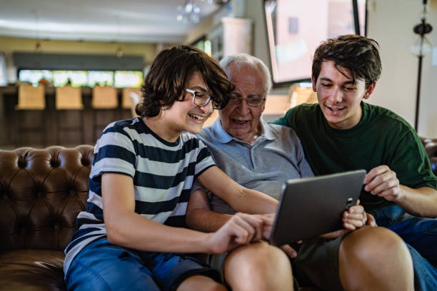 istock Grandsons teaching grandfather to use tablet 1312807198