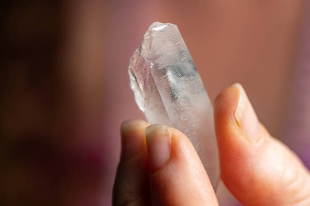 istock Raw Clear Quartz Crystal Held by Caucasian Woman's Hand 1312807549