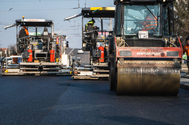 heavy asphalt road roller with heavy vibration roller compactor that press new hot asphalt and asphalt paver machine on a road construction site on a street. - machine operator imagens e fotografias de stock