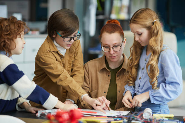 istock Young Female Teacher with Kids in Robotics Class 1312810105