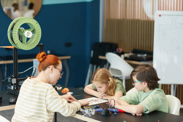 istock Female Teacher with Kids in Robotics Laboratory 1312810135