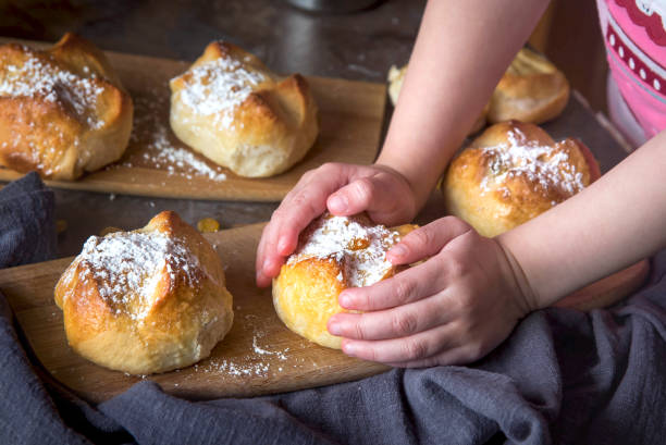 istock Children's hands hold homemade buns with raisins 1312812031