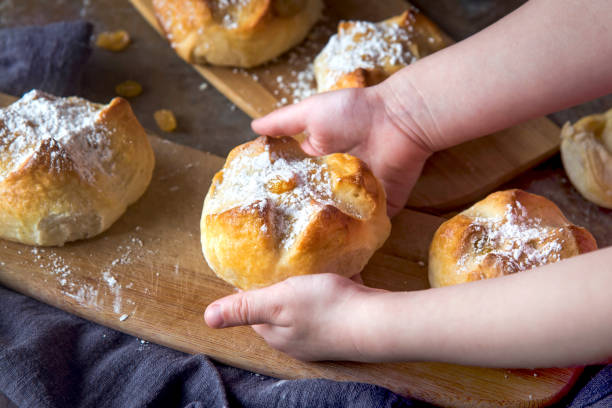 istock Children's hands hold homemade buns with raisins 1312812038