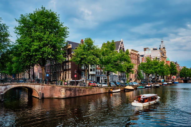 istock Amsterdam view - canal with boad, bridge and old houses 1312813279