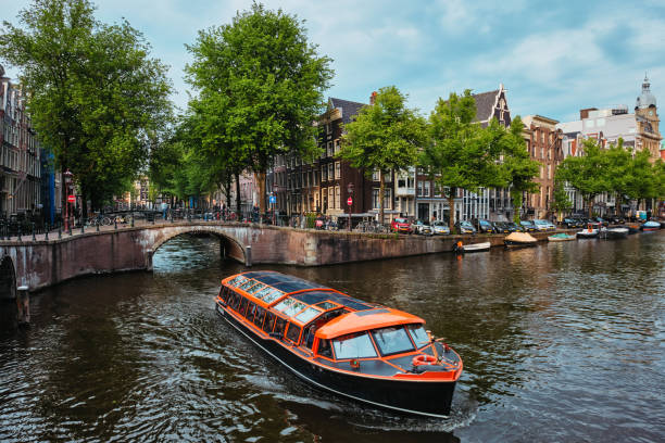 amsterdam blick - kanal mit boad, brücke und alten häusern - narrow boat stock-fotos und bilder