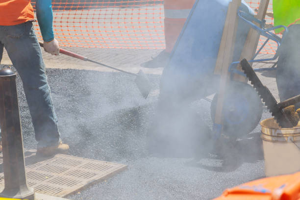 istock Road worker repair asphalt covering new road surface while laying asphalt 1312815238