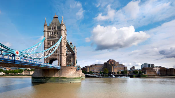 istock Tower Bridge on a bright sunny day with blue sky and clouds. Calm water with reflections. London, England, UK 1312816853