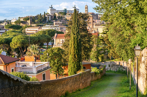 The ancient and almost unknown uphill road of Clivio di Monte Savello, which from the Tiber river leads to the top of the Aventine hill. On the horizon the white building of the Altare della Patria or Vittoriano, the Italian National Memorial Monument, and the bell tower of the Roman Capitol (Campidoglio), seat of the Rome Municipality. Image in High Definition format.