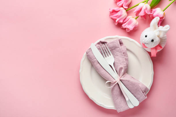 istock Easter table setting with floral decor on pink table. Elegance dinner. Mock up. Top view. 1312817115