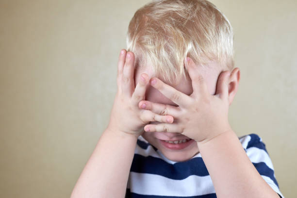 istock Little lonely boy covered his face with his hands. 1312818089