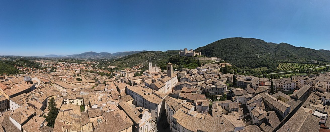 Spoleto city street and wall, with churches and old buildings, drone shooting, in summer in the sun