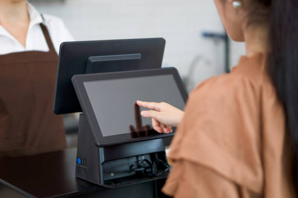 istock Young asian customer orders a beverage menu by choosing from a computer monitor at the counter. Waiter in an apron is waiting for orders on the other side. 1312819487
