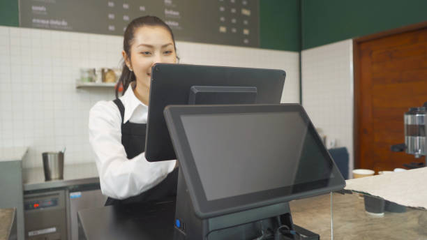 istock Asian woman barista people in apron working on POS system machine with blank empty space screen monitor on counter, cafe restaurant cashier. waitress in coffee shop. People lifestyle. Business service 1312820920