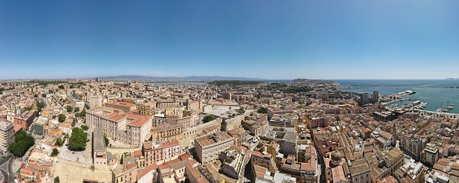 Sardinia in summer, sunny, panoramic view from above, blue sea with dry Mediterranean plants, distant medieval town, Bosa, River and Mountains
