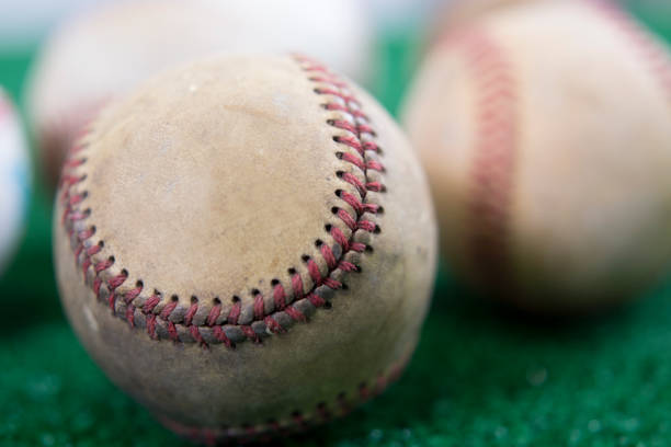 istock Collection of new and used baseballs on artificial turf. 1312823323